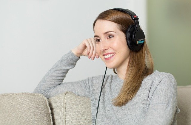 žena poslouchající hudbu ze sluchátek